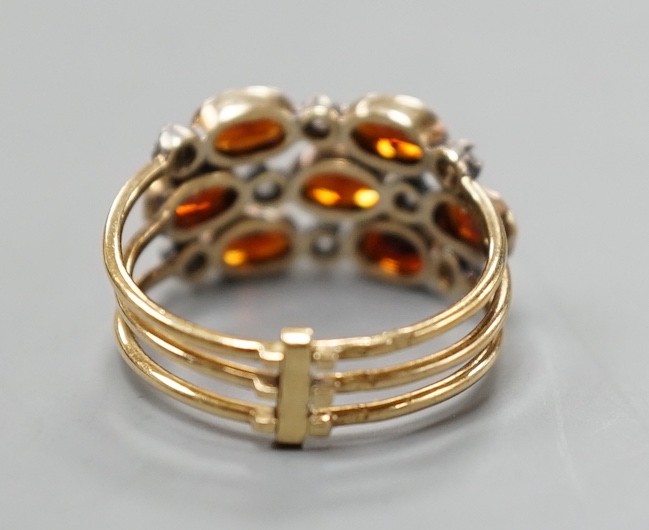 A late Victorian yellow metal, garnet and diamond chip cluster set triple shank ring, size M, gross weight 3.6 grams.